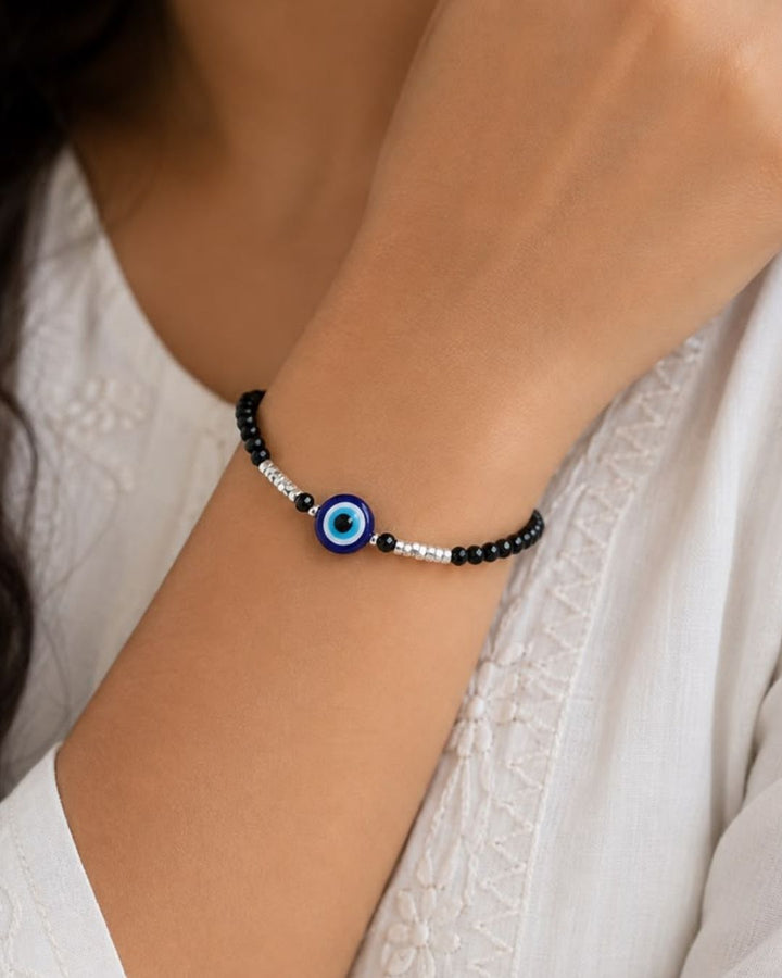 Beautiful black beaded evil eye bracelet featuring faceted black beads, silver bead accents, and a striking blue evil eye centerpiece. Perfect for daily wear, casual outfits, gifting, and stylish occasions.