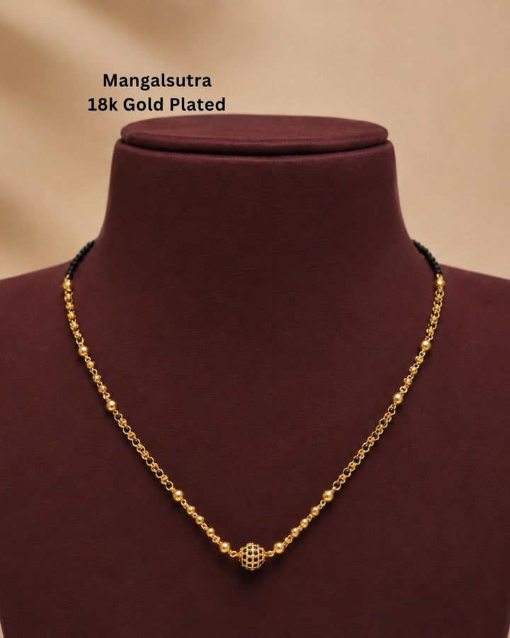 Gold replica black beads necklace featuring a delicate single-strand design, small gold-toned beads, and a decorative round center pendant, displayed on a maroon jewellery bust.