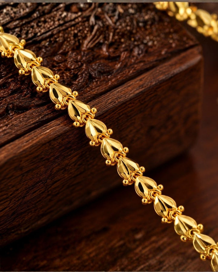 Gold plated men’s chain displayed in hand, showcasing its decorative leaf-shaped links and shiny finish.
