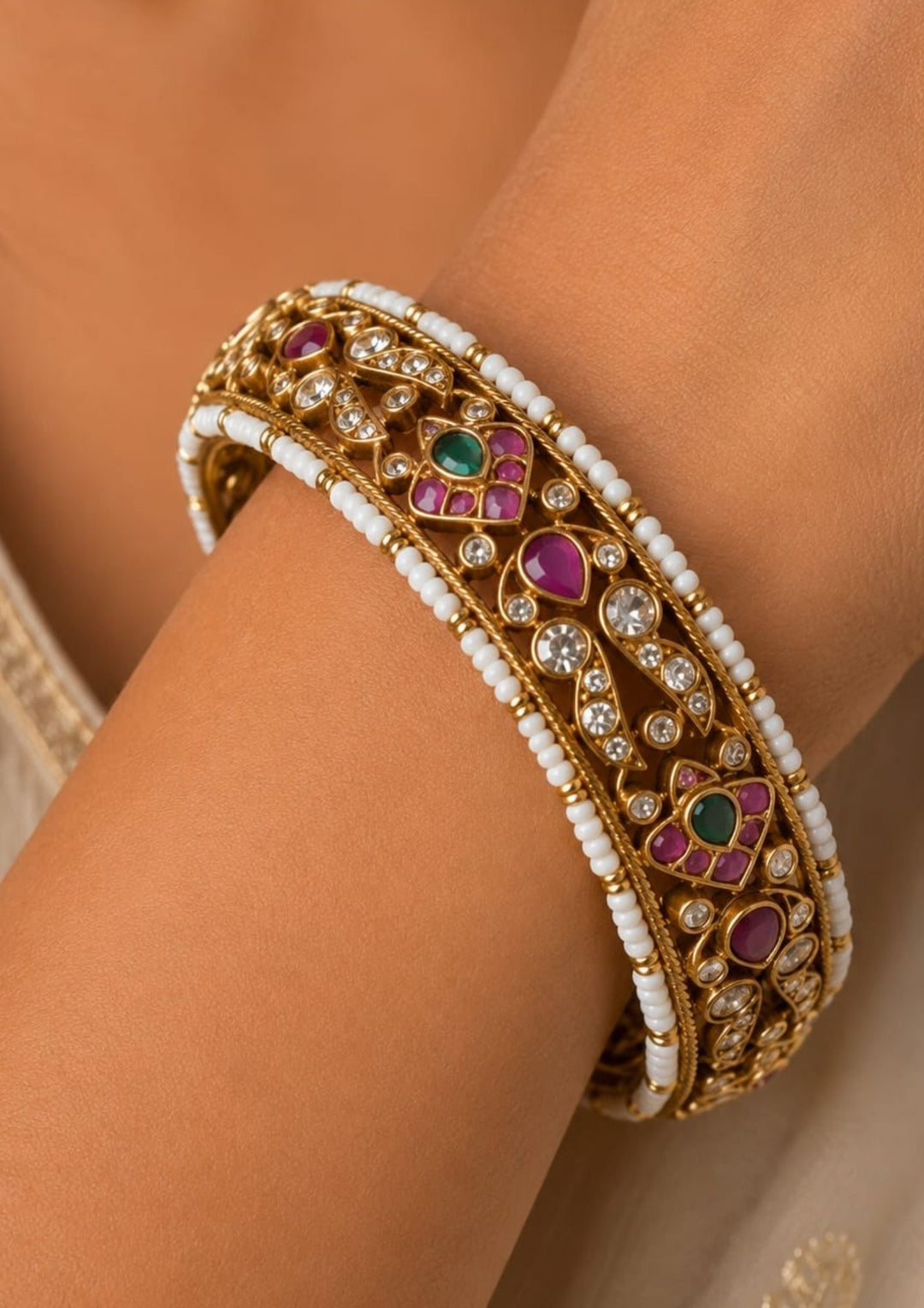 Beautiful Jadau Kundan gold plated openable kada adorned with ruby, green stones, dazzling Kundan work, and pearl detailing. Perfect for weddings, festive occasions, traditional wear, and premium gifting.