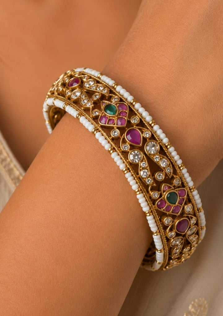 Beautiful Jadau Kundan gold plated openable kada adorned with ruby, green stones, dazzling Kundan work, and pearl detailing. Perfect for weddings, festive occasions, traditional wear, and premium gifting.