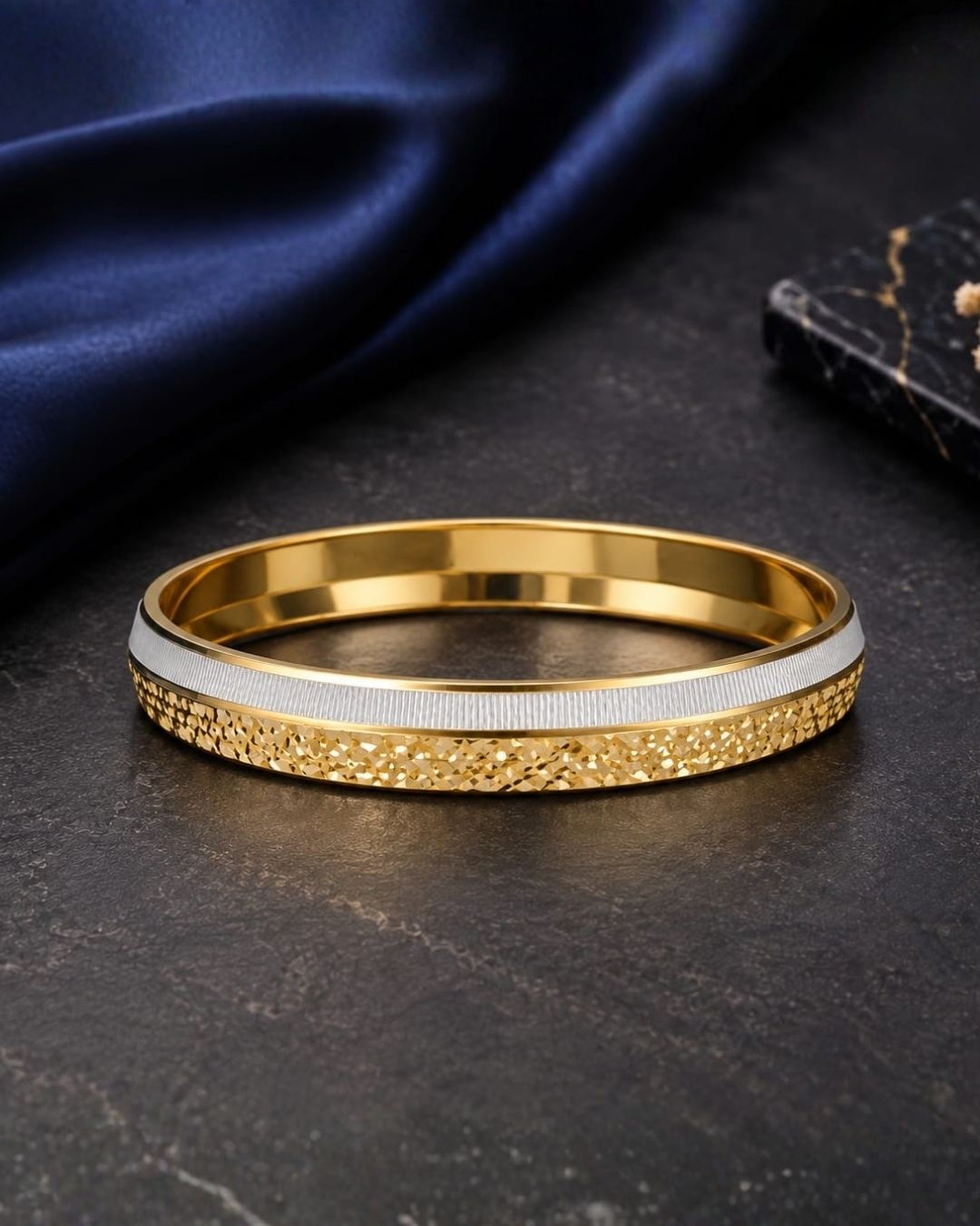 Elegant gold plated men’s kada featuring a sleek dual-tone design, intricate textured detailing along the outer band, and a contrasting silver-tone center strip, perfect for daily wear, festive occasions, parties, and modern looks.