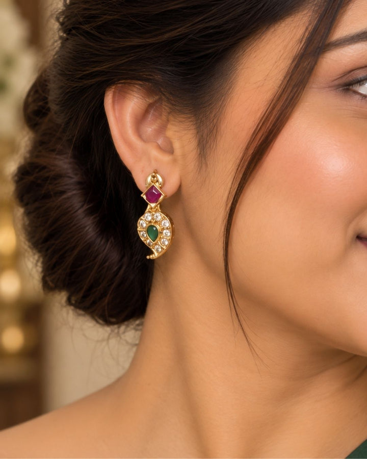 Traditional brass base 18K gold plated necklace set featuring detailed gold motifs, emerald and ruby stones, zircon embellishments, a statement pendant, pearl drops, and matching earrings.
