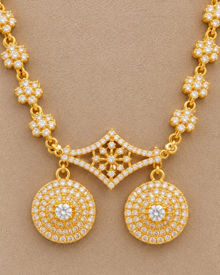 Elegant gold plated necklace with sparkling white stones, floral motifs, and two round dangling pendants.