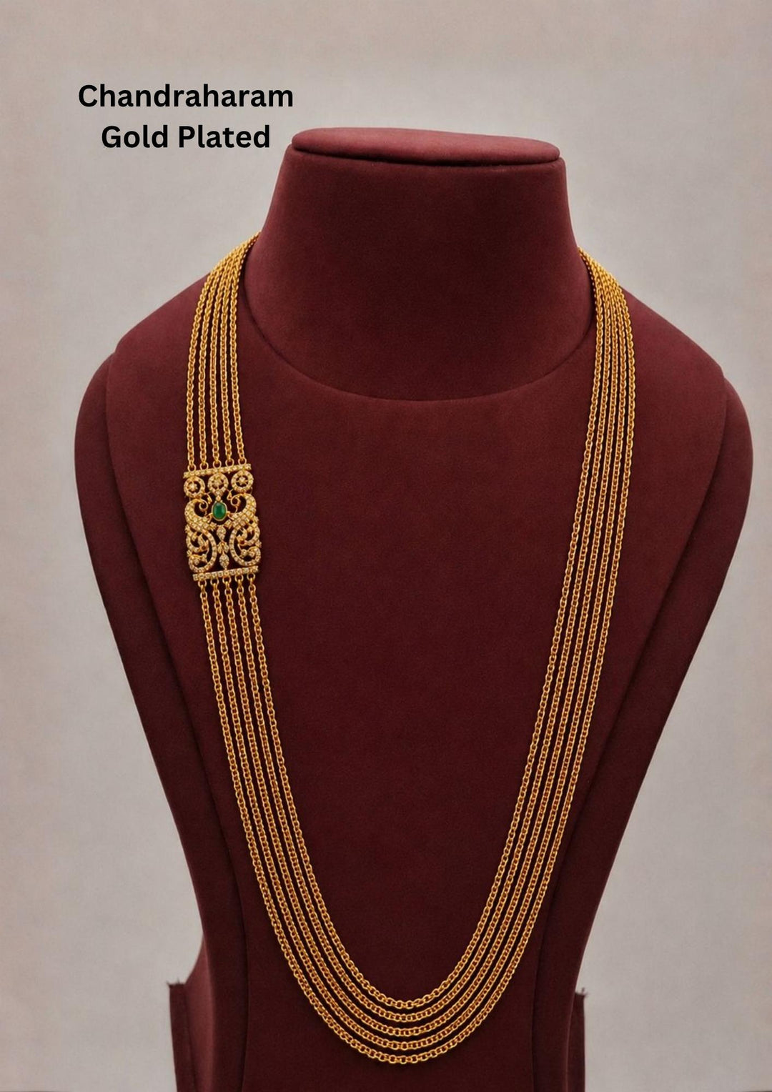 Elegant gold plated Chandraharam necklace with multi-layer chain design. Features a traditional antique-style side pendant with intricate detailing.
Beautiful green stone centerpiece enhances the classic South Indian look. Perfect for weddings, festive wear, and traditional ethnic styling.