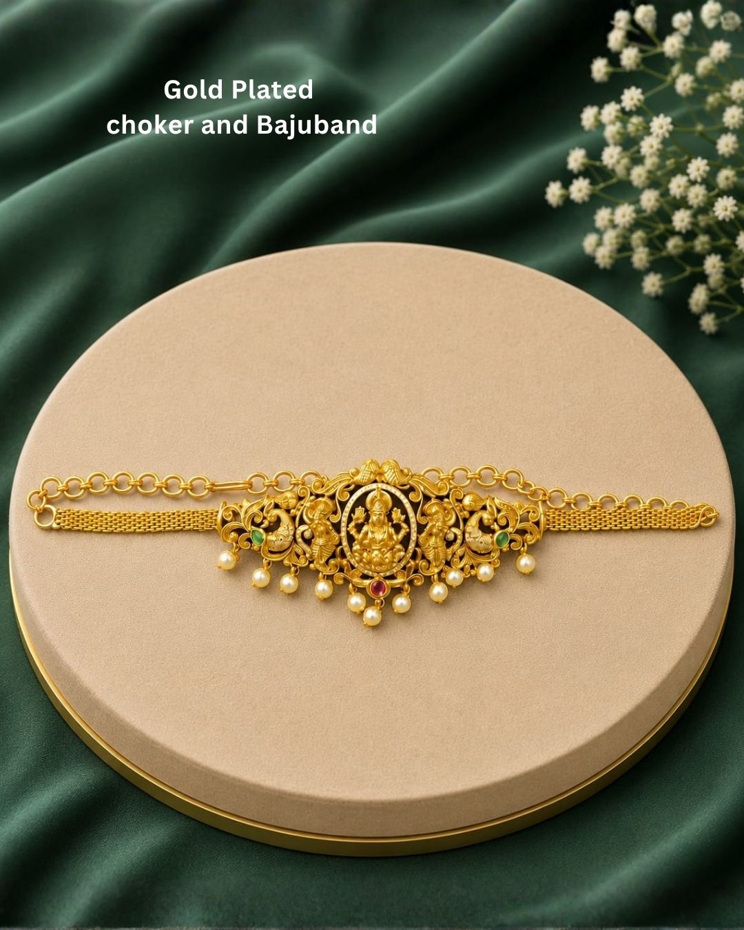 Premium gold plated 2-in-1 choker and bajuband featuring Goddess Lakshmi surrounded by intricate peacock and floral-inspired detailing, accented with green and pink stones and elegant pearl drops. Perfect for weddings, festive occasions, traditional wear, dance performances, parties and gifting.