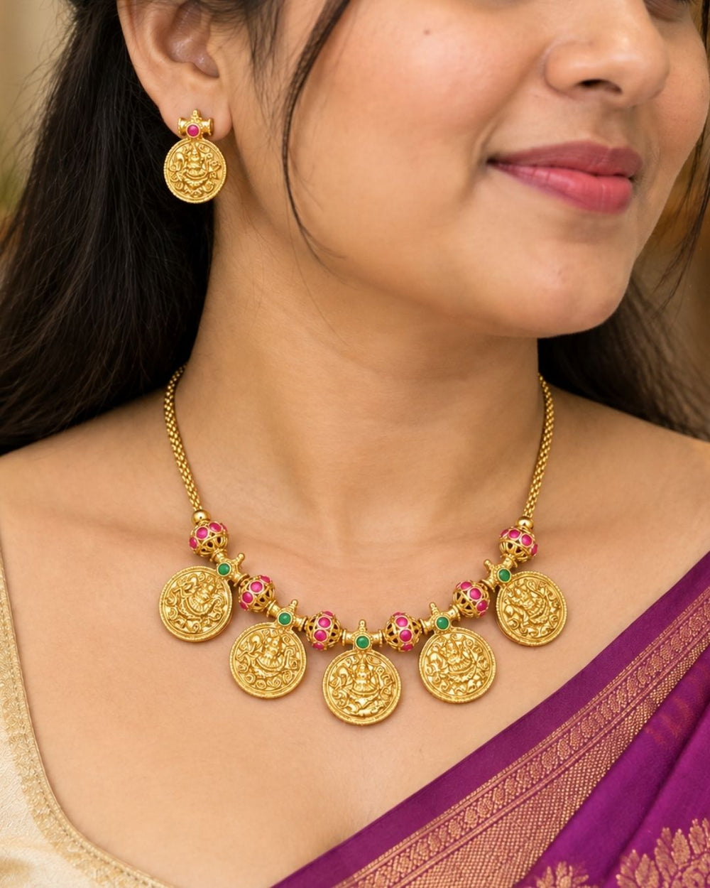 Traditional gold plated designer necklace and earrings set featuring multiple Goddess Lakshmi coin pendants, intricate temple-inspired detailing, ruby and green stone accents, and matching Lakshmi coin earrings, perfect for festive, wedding, and traditional occasions.