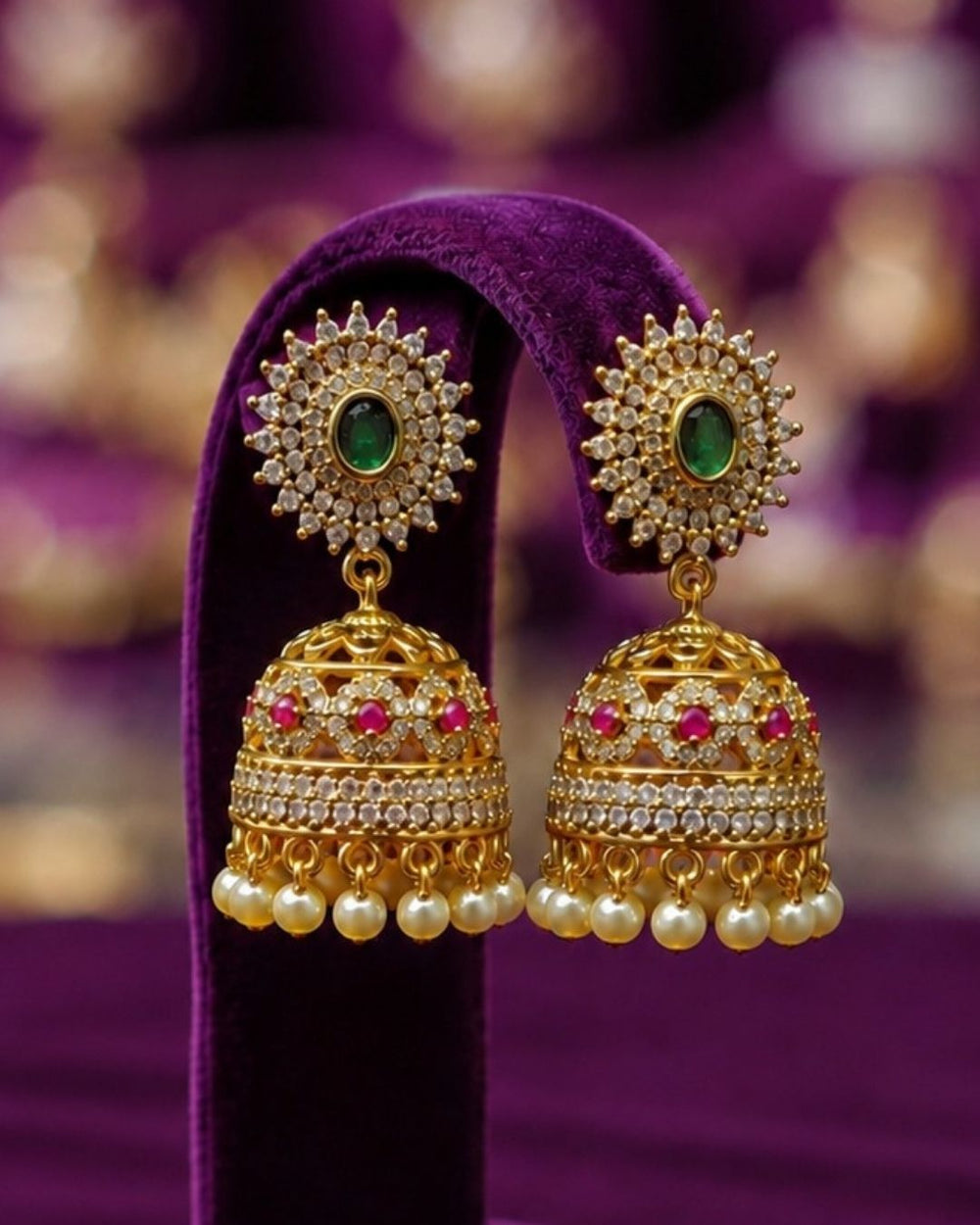 Traditional gold plated bangle and jhumka earrings set featuring CZ stones, green gemstones, pink accents, pearl hangings, and a luxurious velvet presentation for festive occasions.