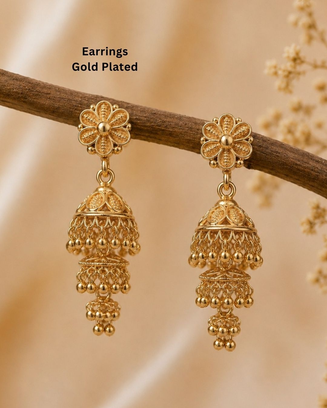 Beautiful traditional gold plated jhumka earrings featuring floral-inspired studs, intricate layered jhumka craftsmanship, decorative patterns, and elegant hanging gold bead accents. Perfect for sarees, festive occasions, weddings, and traditional events.