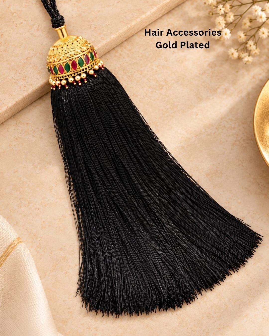 Elegant gold plated Jada Gantalu with an ornate dome-shaped design, green and pink stones, pearl and bead accents, and long black tassels, perfect for bridal and festive hairstyles.