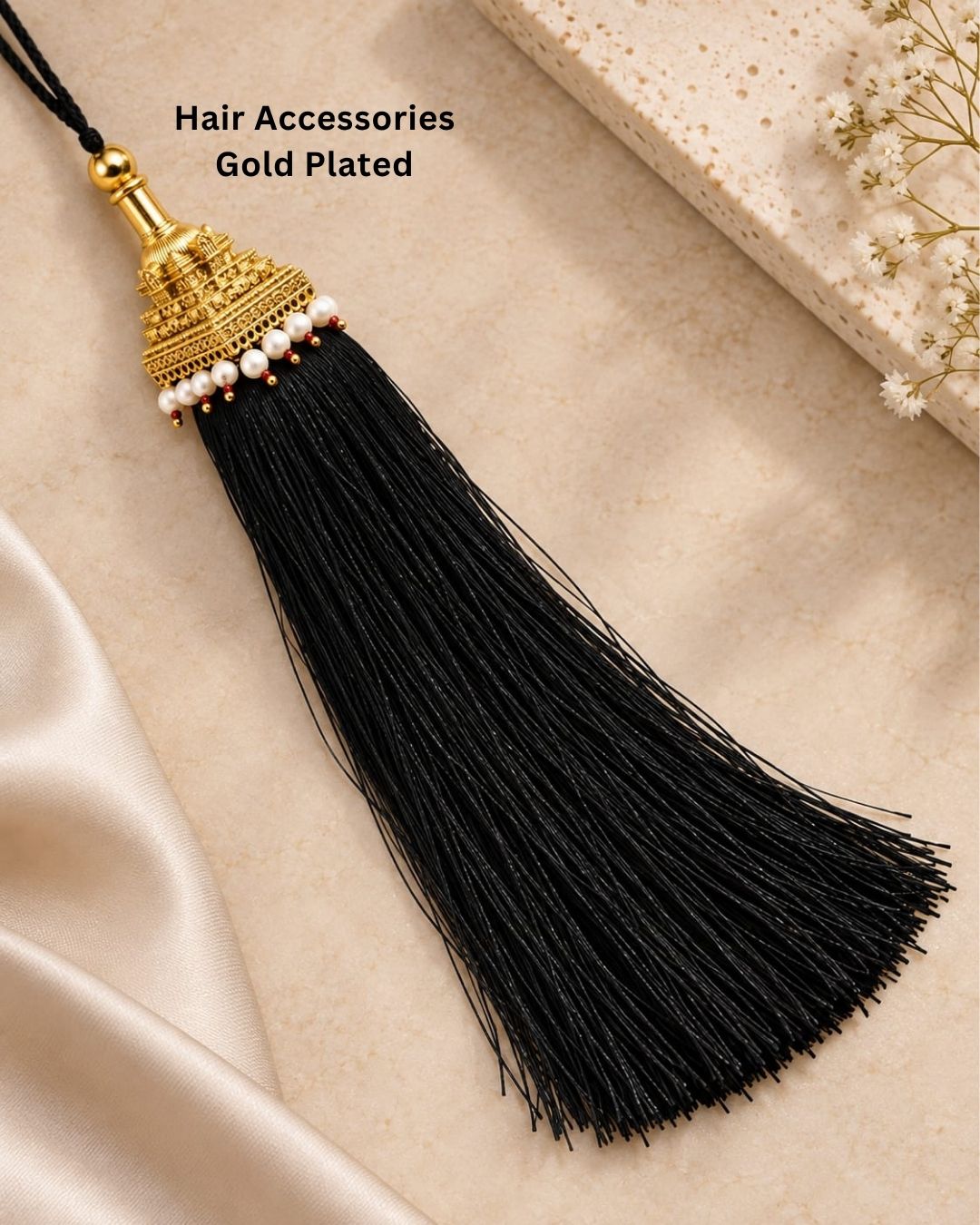 Elegant gold plated Jada Gantalu featuring a detailed temple-style design, white pearl accents, red bead detailing, and long flowing black tassels, perfect for traditional occasions and bridal looks.