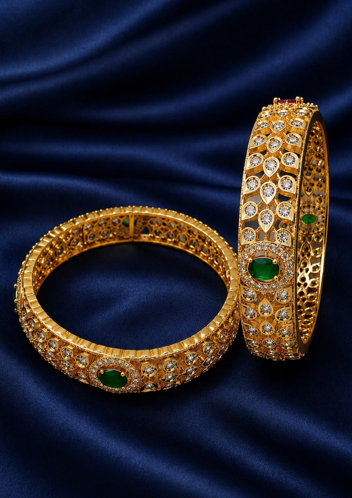 Beautiful Jadau Kundan gold plated openwork bangle pair featuring dazzling white kundan stones, emerald green center stones, and intricate traditional craftsmanship. Perfect for weddings, festivals, temple visits, traditional outfits, family functions, and premium gifting.