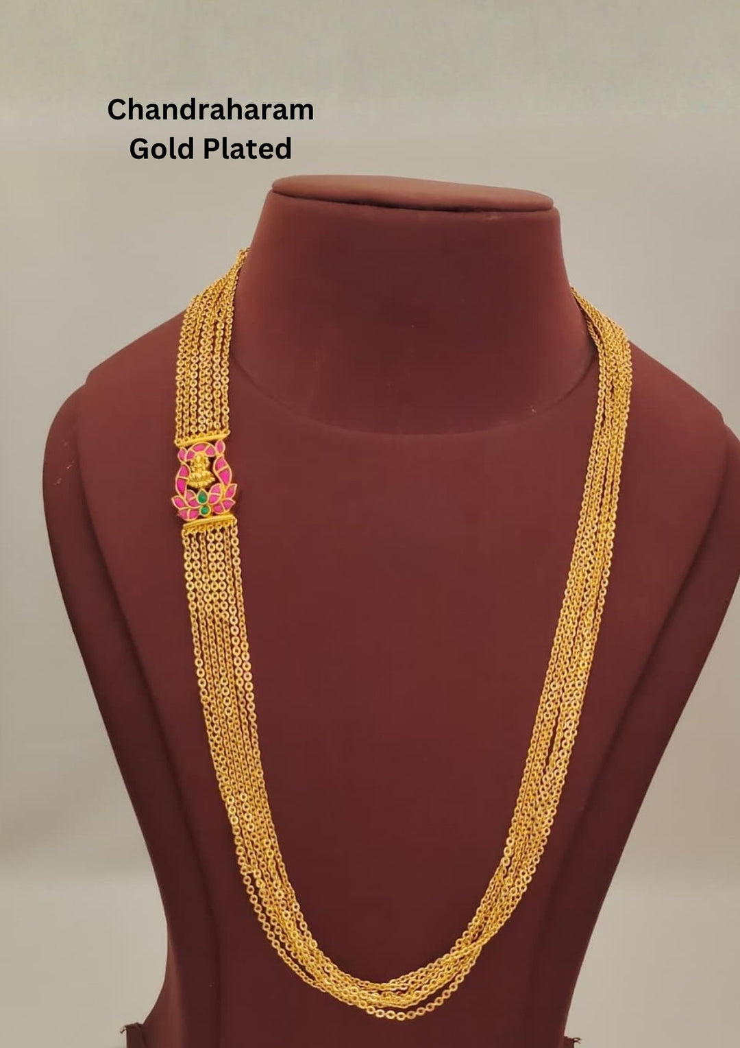 Elegant gold plated multi-layer chain featuring delicate strands joined with a traditional Lakshmi motif connector highlighted with pink and green stone accents. The lightweight layered design offers a graceful traditional look suitable for daily ethnic styling and festive wear.