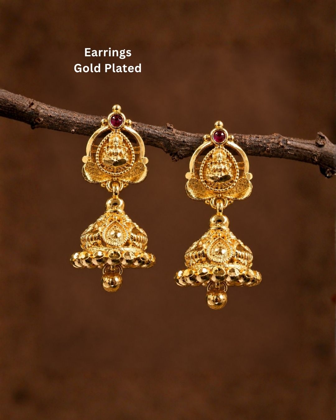 Beautiful traditional gold plated Lakshmi jhumka earrings featuring intricate temple-inspired craftsmanship, red stone detailing, ornate floral patterns, and hanging gold beads. Perfect for sarees, festive occasions, weddings, and traditional events.
