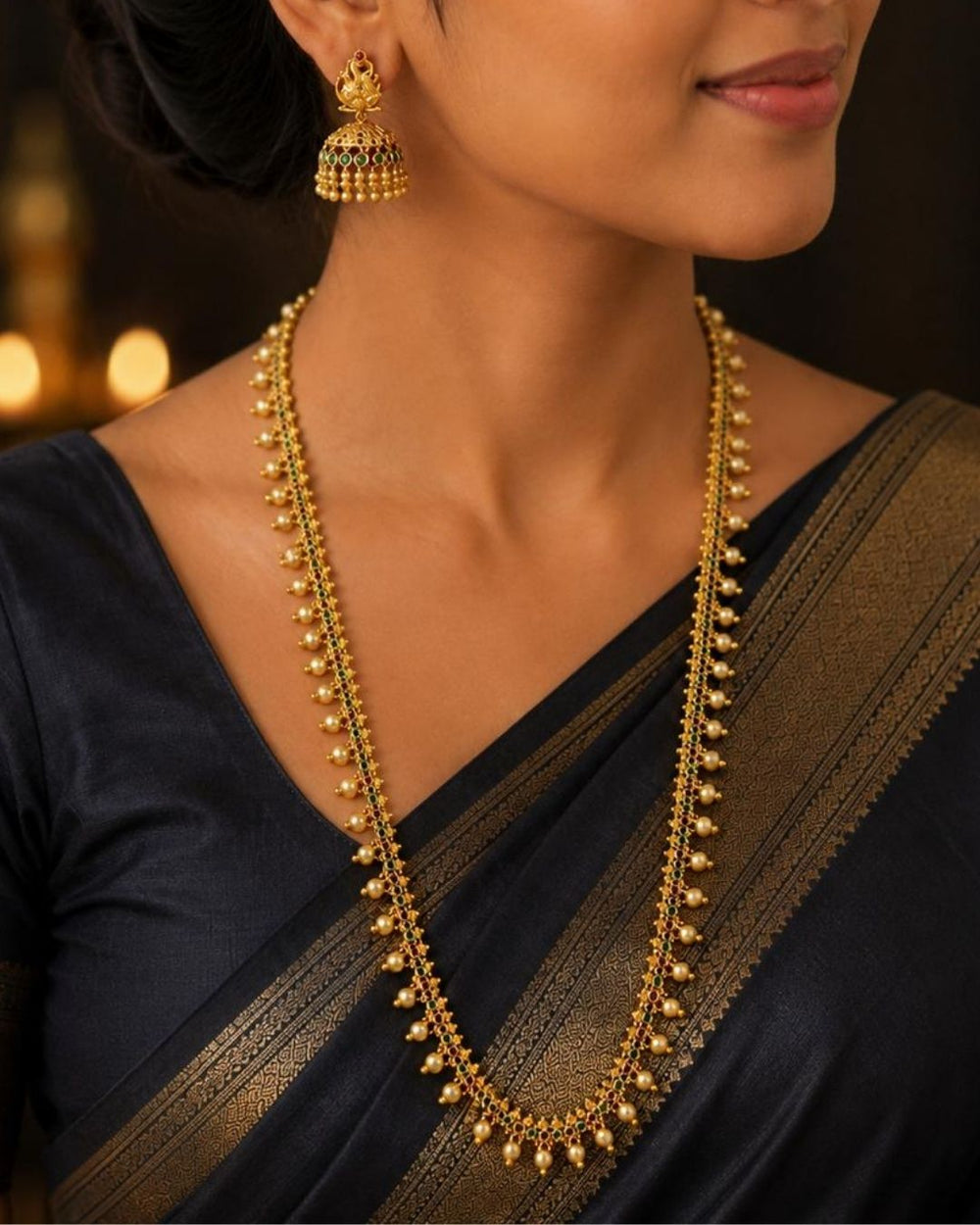 Beautiful gold plated necklace set featuring intricate green and ruby stonework, delicate pearl drop embellishments, and matching peacock-inspired jhumka earrings. Perfect for weddings, bridal wear, festive occasions, traditional outfits, parties, and gifting.