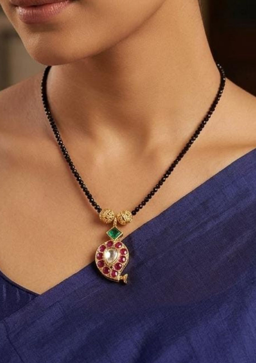 South indian women's Elegant gold plated black bead mangalsutra showcasing a paisley-shaped pendant adorned with ruby stones, a green gemstone accent, and a sparkling kundan centerpiece, perfect for daily wear, festive occasions, weddings, and traditional styling.
