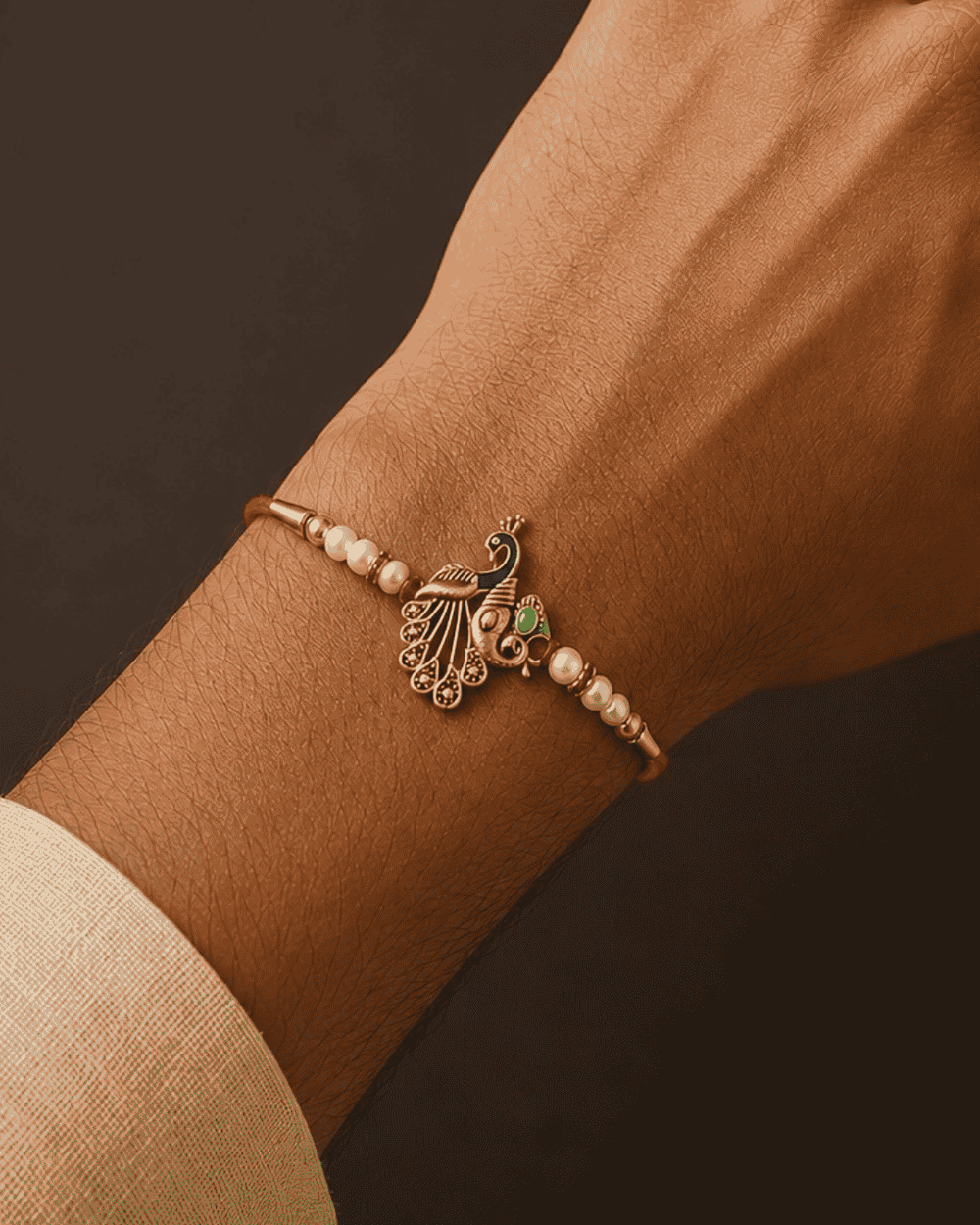 Beautiful Peacock Beads gold plated Rakhi featuring pearl beads, colorful peacock detailing, and an elegant handcrafted design. Perfect for Raksha Bandhan celebrations and thoughtful gifting.