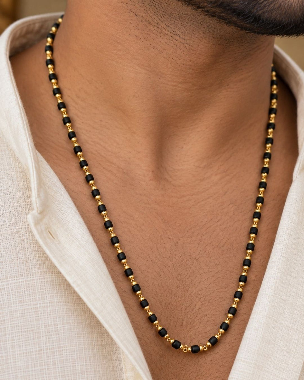 Beautiful Rudraksha Mala featuring black textured beads with delicate gold plated separators and a traditional long-chain design. Perfect for daily wear, spiritual occasions, temple visits, traditional outfits, festive occasions, and gifting.
