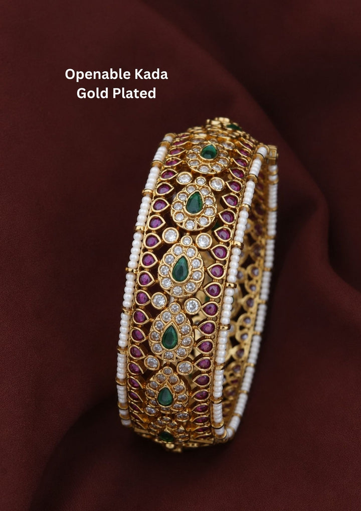  Beautiful Jadau Kundan gold plated openable kada adorned with green stones, ruby accents, sparkling Kundan work, and pearl detailing. Perfect for weddings, festive occasions, traditional wear, and premium gifting.