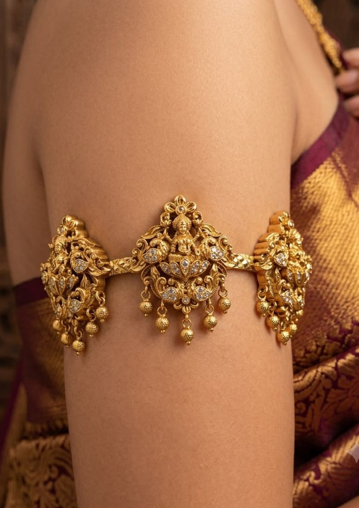 Close up of a south indian women wearing Beautiful traditional gold plated Baju Bandh showcasing intricate Lakshmi temple craftsmanship with sparkling zircon detailing and hanging beads. Perfect for bridal wear, weddings, classical dance, and festive celebrations.