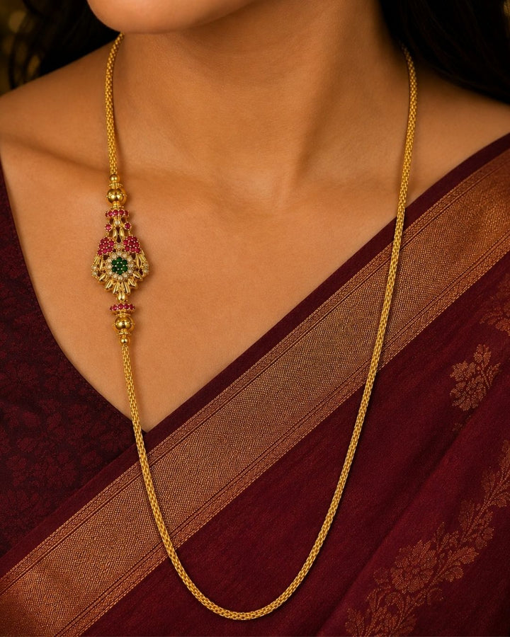 Beautiful gold plated thaali chain featuring a fine textured link chain and an intricate multicolour stone-studded pendant with ruby and green accents. Perfect for weddings, traditional wear, festive occasions, and gifting.