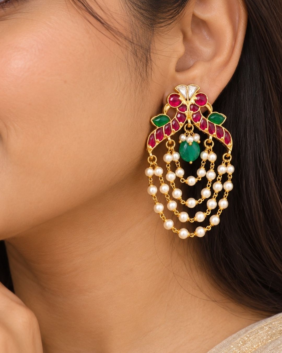 Traditional style gold plated Jadau crescent chandbali earrings designed with screwback stems, vibrant pink-green stone layouts, and four hanging layers of micro pearl chains that give a graceful traditional look for festive celebrations, poojas, family functions, and bridal outfits.