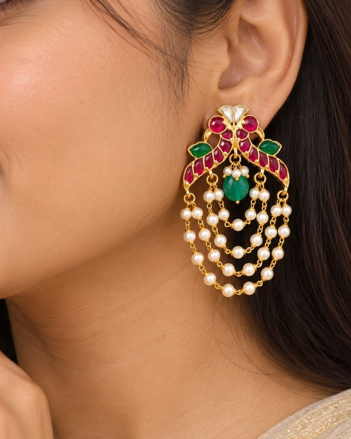 Traditional style gold plated Jadau crescent chandbali earrings designed with screwback stems, vibrant pink-green stone layouts, and four hanging layers of micro pearl chains that give a graceful traditional look for festive celebrations, poojas, family functions, and bridal outfits.