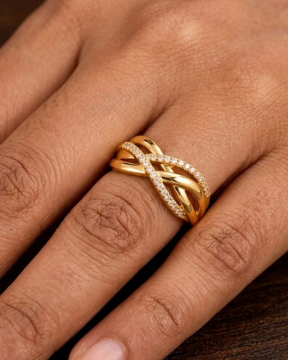 Stylish gold plated adjustable ring with a layered crossed-band design and sparkling crystals, perfect for everyday and occasion wear.