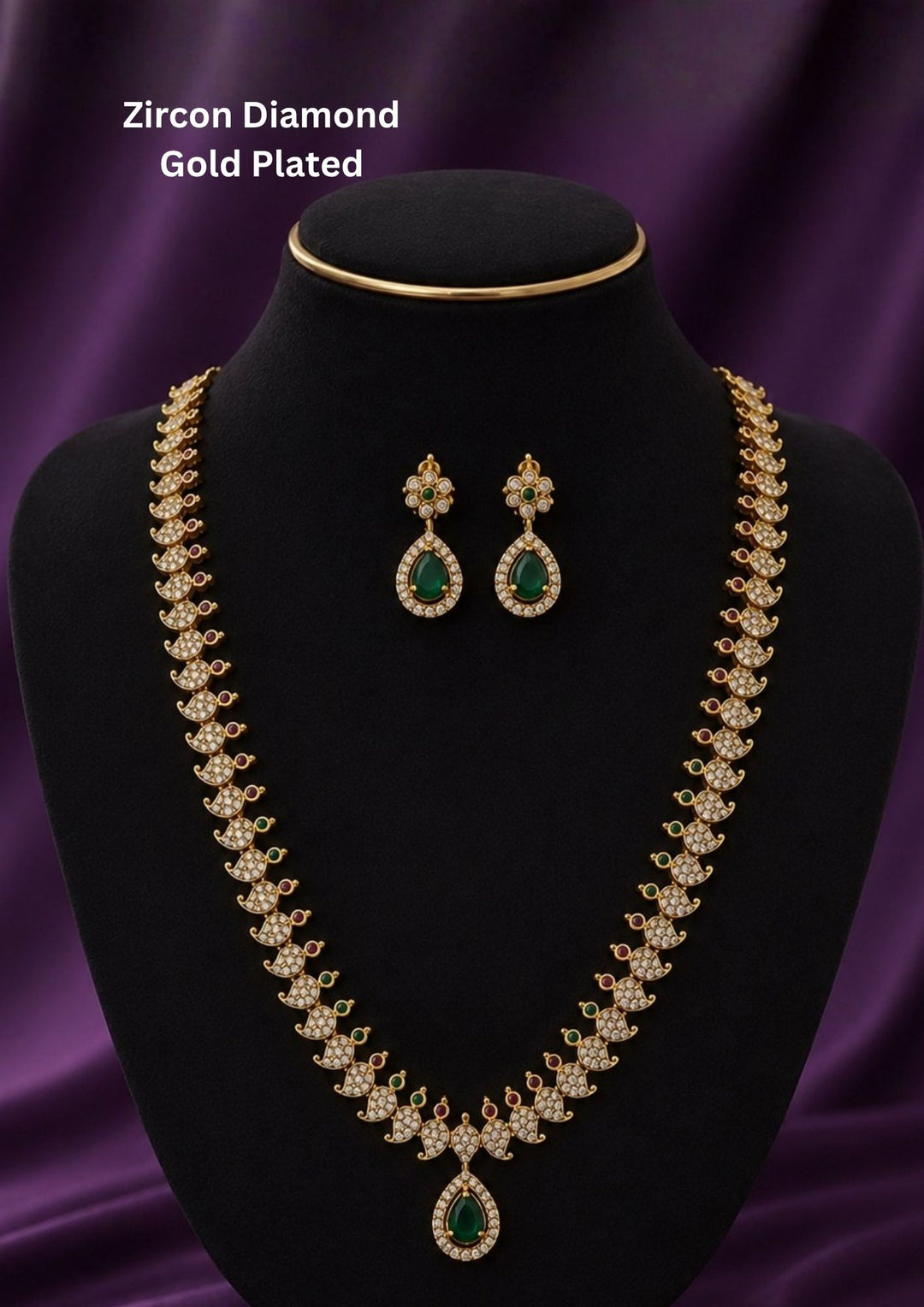 Gold-plated traditional Indian jewelry set featuring a necklace and matching earrings with green teardrop-shaped stones and clear stones Premium gold plated long haram featuring sparkling zircon stones with ruby and emerald accents, paired with matching earrings.