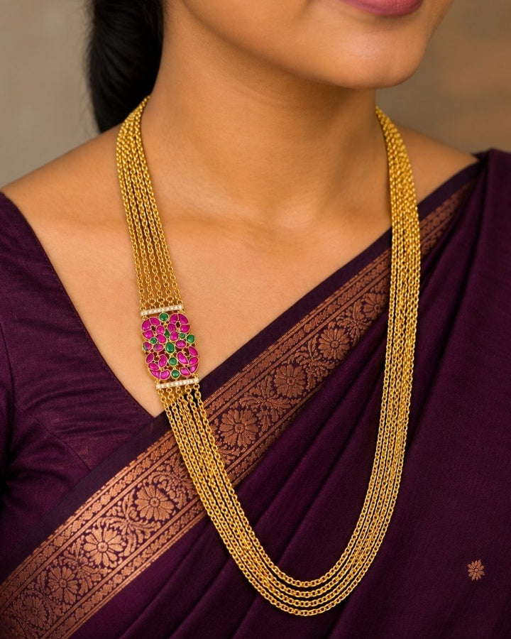 Beautiful multicolor stone gold plated long necklace featuring multiple layered chains and a detailed pink and green stone pendant. Perfect for festive occasions, traditional outfits, parties, temple visits, and gifting.