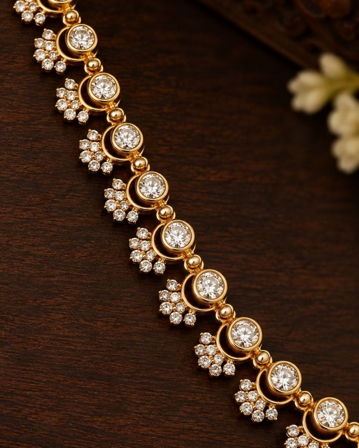 Woman wearing a zircon diamond gold plated long haram necklace resting on dark wood alongside matching earrings that give a graceful traditional and modern look for formal receptions and wedding parties with COD.