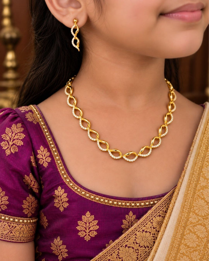 Beautiful gold plated loop necklace set featuring interlinked curved motifs accented with sparkling clear stones and matching elegant drop earrings. Perfect for daily wear, festive occasions, parties, traditional outfits, and premium gifting.