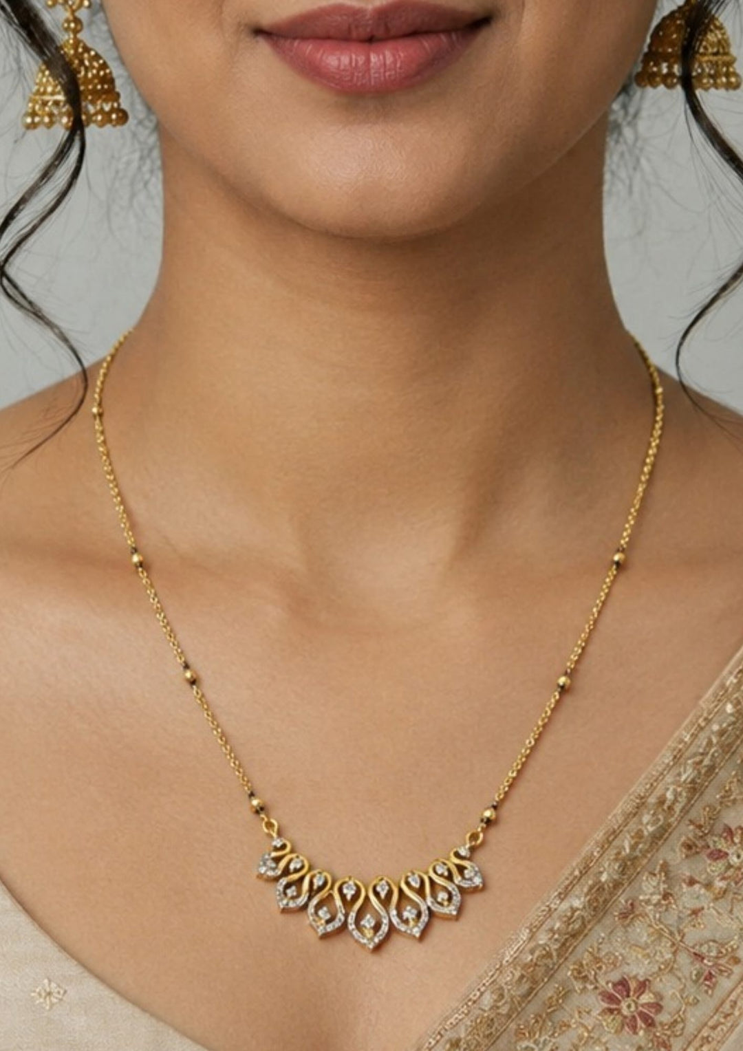Gold necklace with a decorative pendant worn by a model Modern Zircon Diamond gold plated mangalsutra necklace The design features a delicate gold link chain transitioning into sections of traditional small black beads on both sides. The central pendant showcases a sleek, contemporary curved V-shape and a stylized butterfly or floral motif encrusted with sparkling white cubic zirconia stones. This elegant neckpiece perfect for daily wear, office wear, and casual outfits.