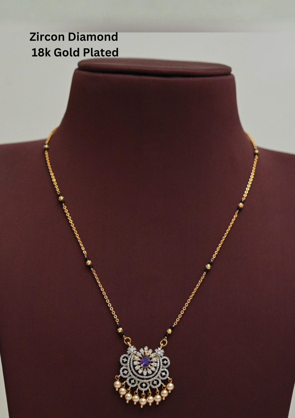 Modern Zircon Diamond gold plated mangalsutra necklace The design features a delicate gold link chain transitioning into sections of traditional small black beads on both sides. The central pendant showcases a sleek, contemporary curved u-shape and a stylized butterfly or floral motif encrusted with sparkling white cubic zirconia stones. This elegant neckpiece perfect for daily wear, office wear, and casual outfits.