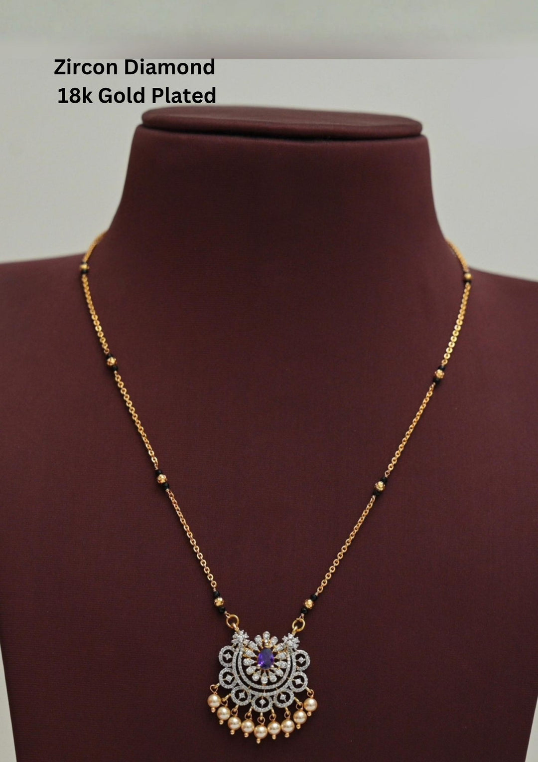 Modern Zircon Diamond gold plated mangalsutra necklace The design features a delicate gold link chain transitioning into sections of traditional small black beads on both sides. The central pendant showcases a sleek, contemporary curved u-shape and a stylized butterfly or floral motif encrusted with sparkling white cubic zirconia stones. This elegant neckpiece perfect for daily wear, office wear, and casual outfits.