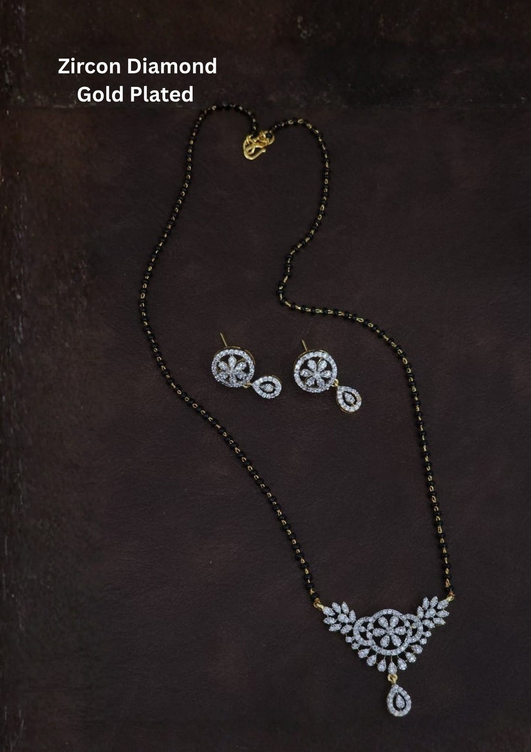 Gold plated black beads mangalsutra featuring an elegant classy -inspired zircon centerpiece with delicate curved detailing. Lightweight and beautifully crafted for everyday elegance, festive occasions, and gifting.