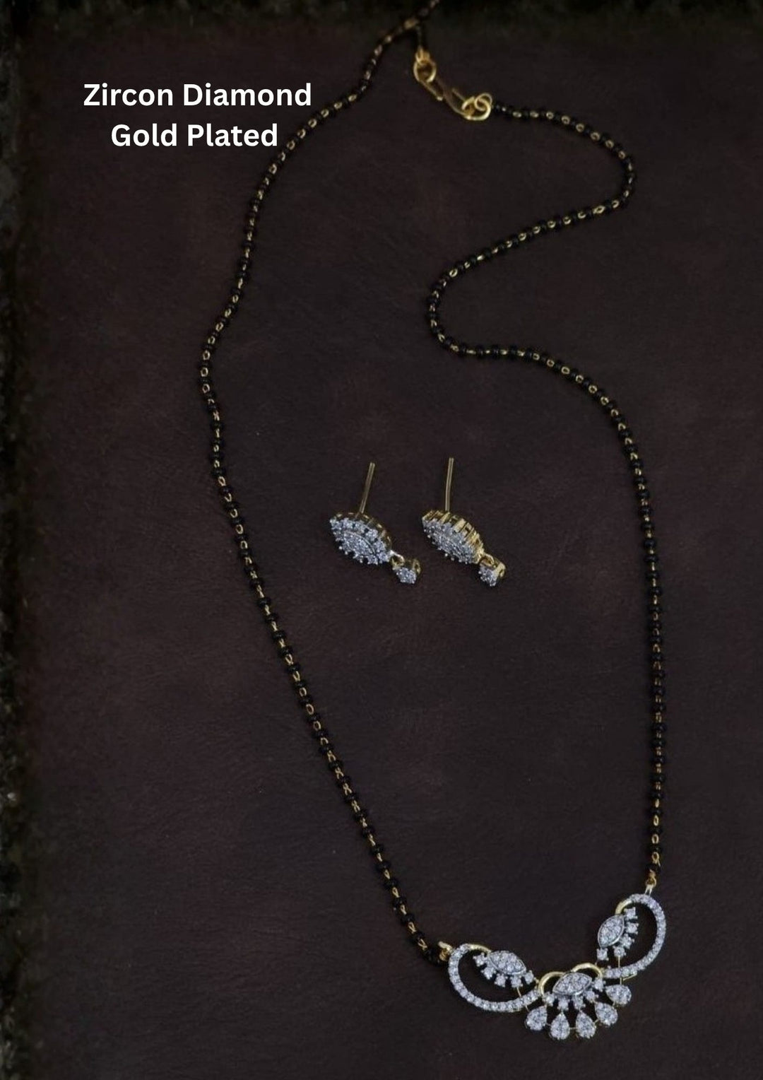 Gold plated black beads mangalsutra featuring an elegant Classic Black Beaded -inspired zircon centerpiece with delicate curved detailing. Lightweight and beautifully crafted for everyday elegance, festive occasions, and gifting.