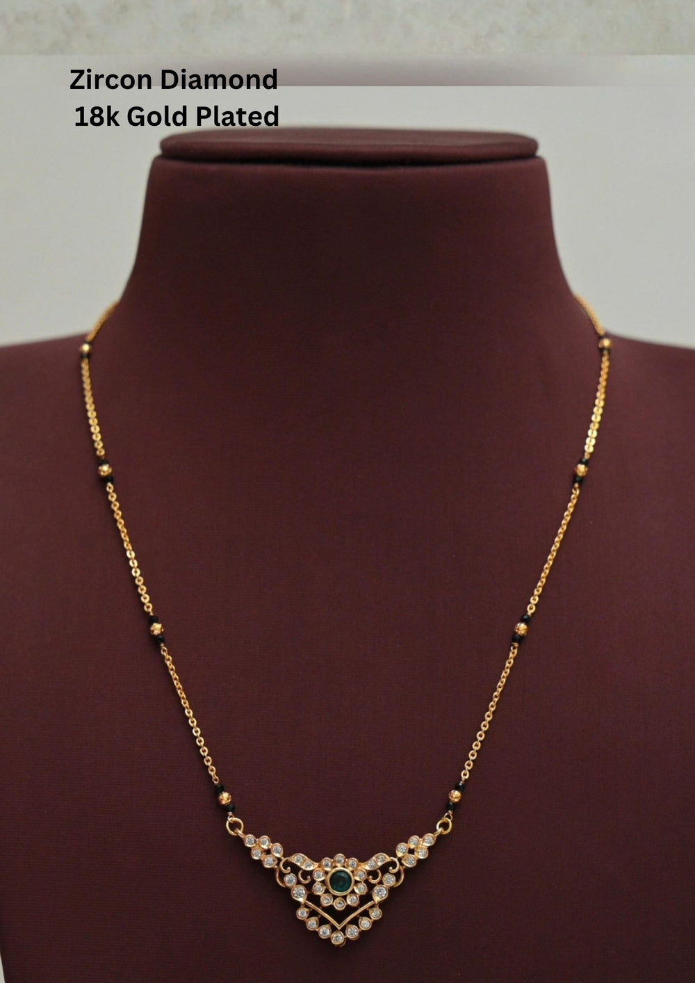 Modern Zircon Diamond gold plated mangalsutra necklace The design features a delicate gold link chain transitioning into sections of traditional small black beads on both sides. The central pendant showcases a sleek, contemporary curved V-shape and a stylized butterfly or floral motif encrusted with sparkling white cubic zirconia stones. This elegant neckpiece perfect for daily wear, office wear, and casual outfits.