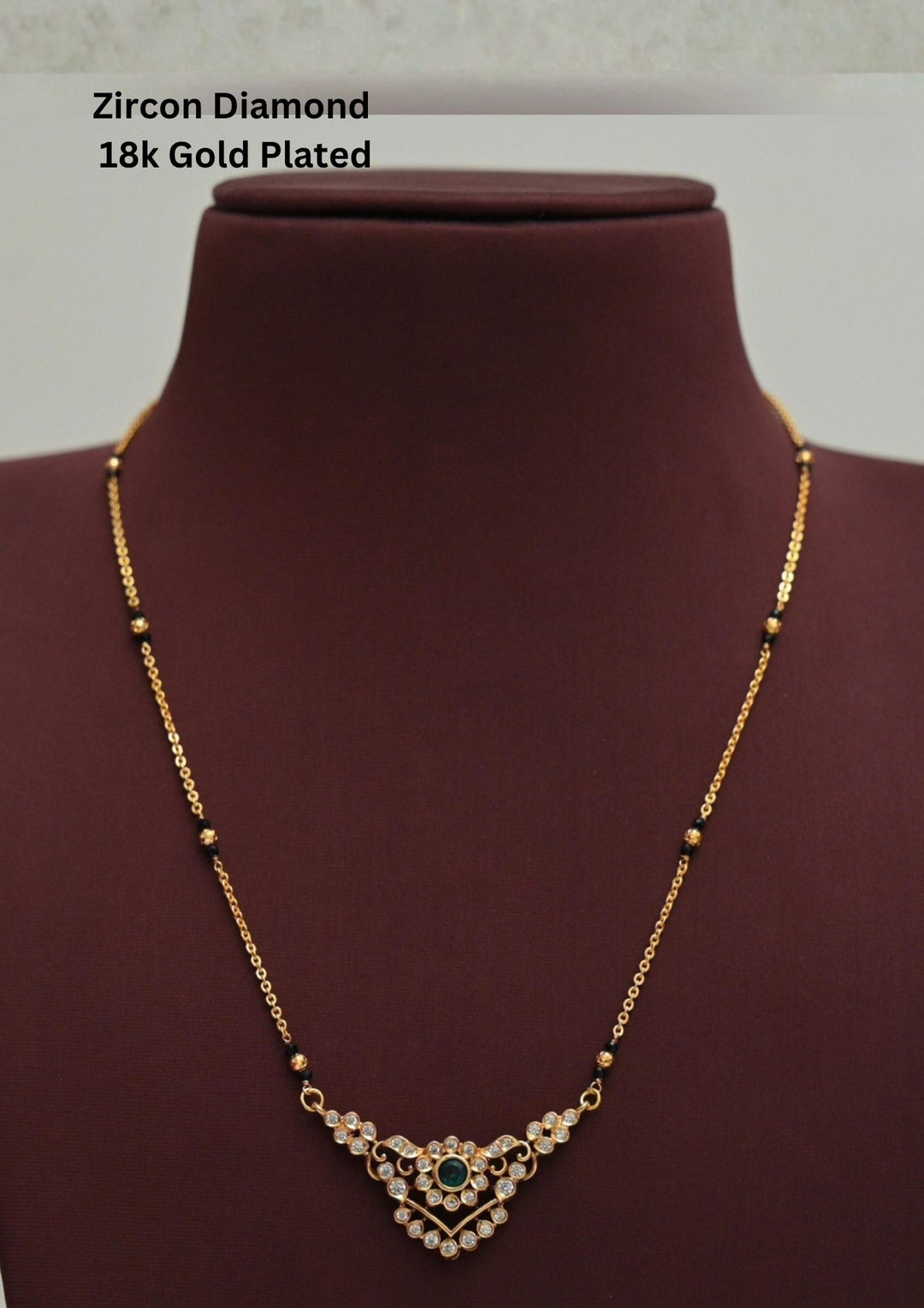 Modern Zircon Diamond gold plated mangalsutra necklace The design features a delicate gold link chain transitioning into sections of traditional small black beads on both sides. The central pendant showcases a sleek, contemporary curved V-shape and a stylized butterfly or floral motif encrusted with sparkling white cubic zirconia stones. This elegant neckpiece perfect for daily wear, office wear, and casual outfits.