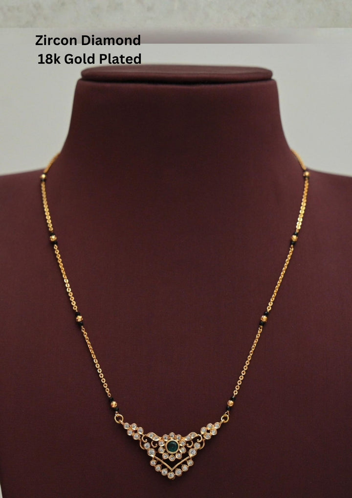 Modern Zircon Diamond gold plated mangalsutra necklace The design features a delicate gold link chain transitioning into sections of traditional small black beads on both sides. The central pendant showcases a sleek, contemporary curved V-shape and a stylized butterfly or floral motif encrusted with sparkling white cubic zirconia stones. This elegant neckpiece perfect for daily wear, office wear, and casual outfits.