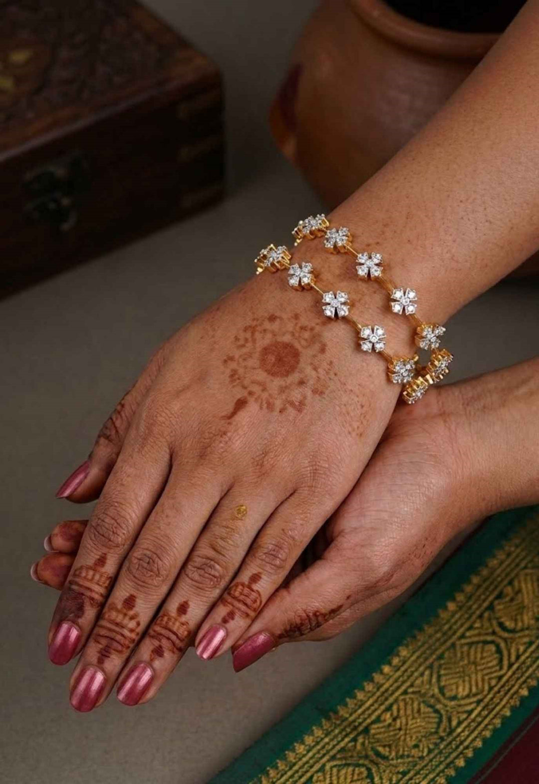 south indian women wearing a gold plated flower bangles come with zircon diamond and in picture shows clearly how it looks looks very classy and simple and ani faded and skin safe and can be used for daily ware, office ware and festivals