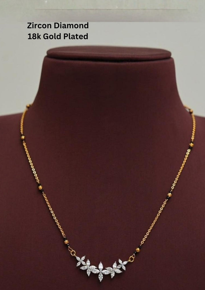 Gold plated black beads mangalsutra featuring an elegant Flower Model classic-inspired zircon centerpiece with delicate curved detailing. Lightweight and beautifully crafted for everyday elegance, festive occasions, and gifting.