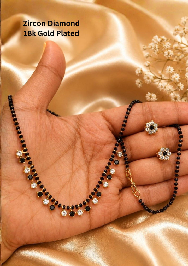 Zircon diamond 18k gold-plated necklace and earrings designed with single line nallapusalu black beads with white and black stones hanging and with matching studs perfect for daily wear and office wear and its anti fade color