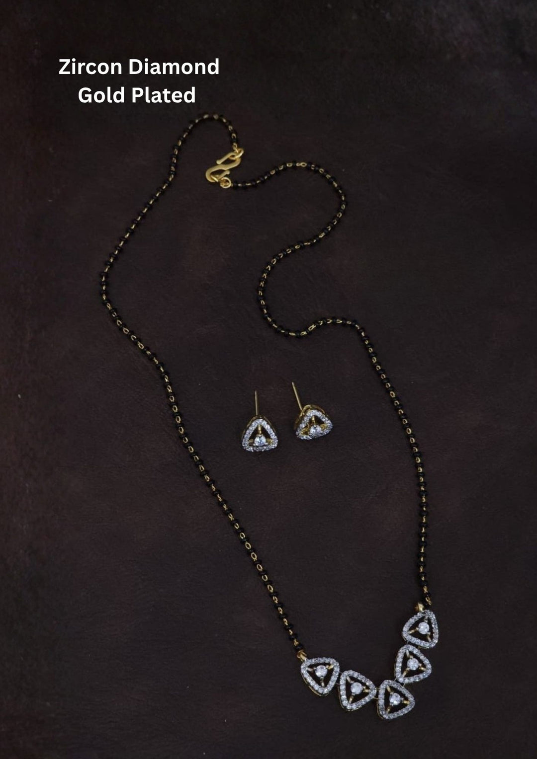Gold plated black beads mangalsutra featuring an elegant Triangular -inspired zircon centerpiece with delicate curved detailing. Lightweight and beautifully crafted for everyday elegance, festive occasions, and gifting.