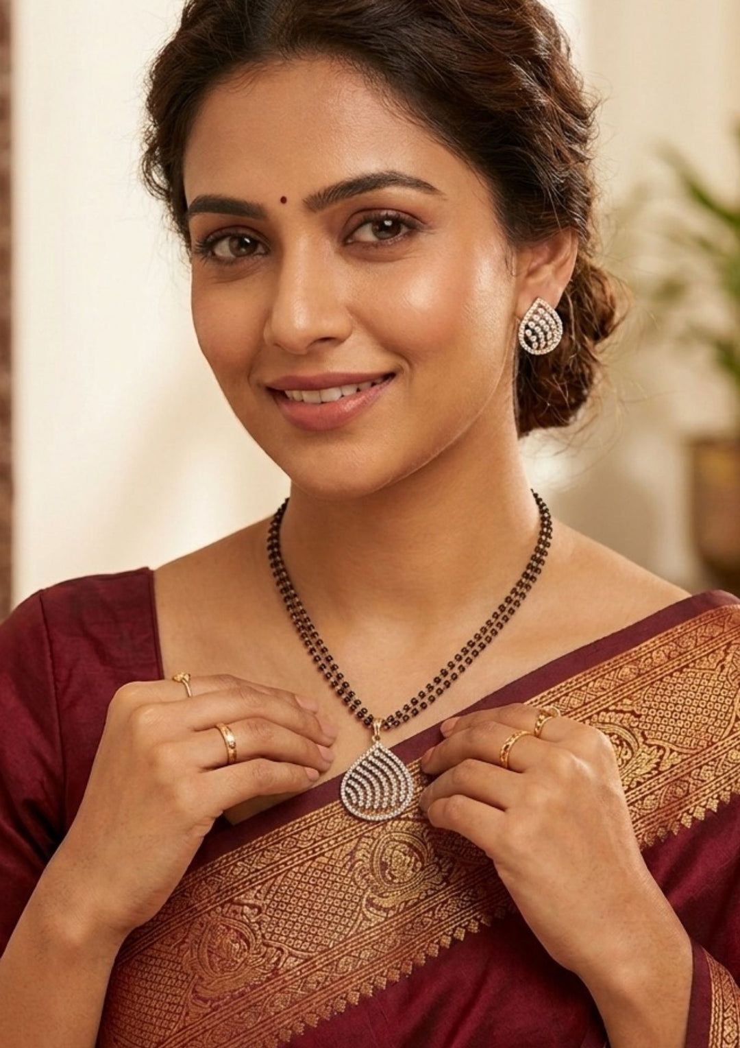 South indian women wearing Modern Zircon Diamond gold plated mangalsutra necklace The design features a delicate gold link chain transitioning into sections of traditional small black beads on both sides. The central pendant showcases a sleek, contemporary curved Tear drop pendant with sparkling white cubic zirconia stones. This elegant neckpiece perfect for daily wear, office wear, and casual outfits.