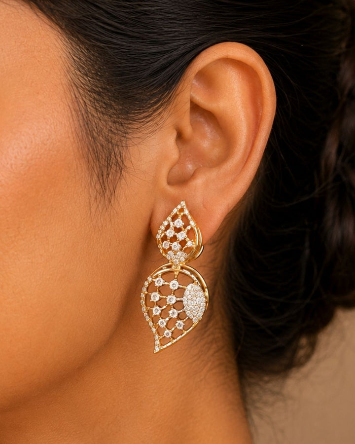 Gold plated jewelry set  featuring a delicate choker necklace made of repeating, stylized leaf or paisley-shaped links. Each openwork link is encrusted with brilliant, clear white Zirconian diamonds (American Diamonds) that catch the light beautifully. Includes a matching pair of elegant hanging earrings mimicking the exact leaf pattern. Crafted for festive occasions and parties with premium quality and Cash on Delivery available.