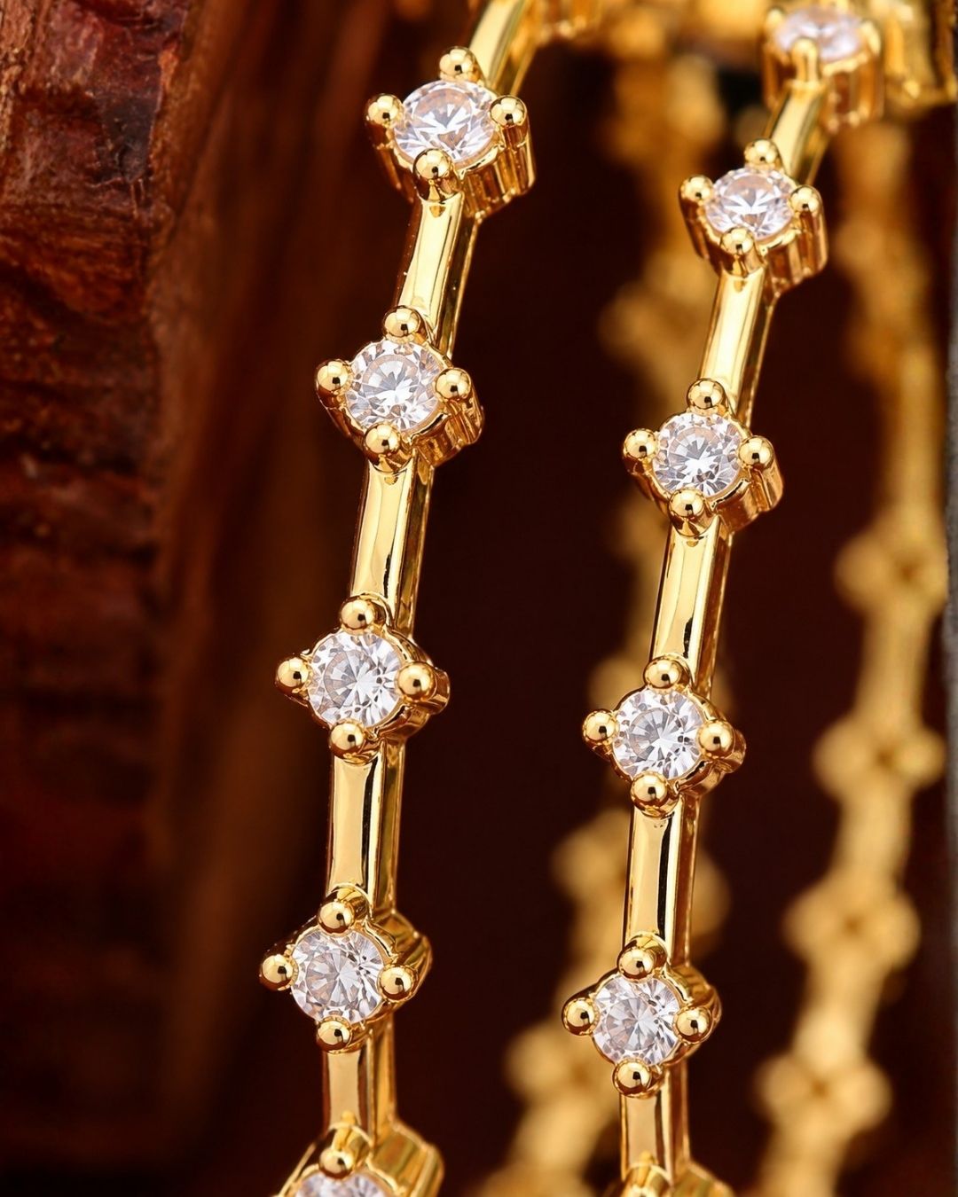 A set of four ultra-slim 18k gold plated eternity-style bangles encrusted with premium pure Zirconian diamonds. Each bangle features a continuous row of brilliant round white crystals secured in delicate square prong settings spaced evenly along a fine golden wire frame. The set is lightweight, highly durable, and skin-friendly.