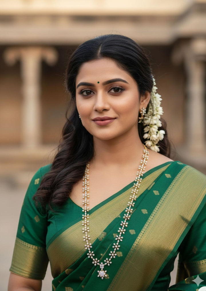 South Indian women wearing  Pure Zirconian Diamond Gold Plated long chain necklace and matching stud earrings set. The jewelry designed with floral pattern made of sparkling cube zirconia stones on a gold-plated base for festivals, temple visits, weddings, functions and dailywear
