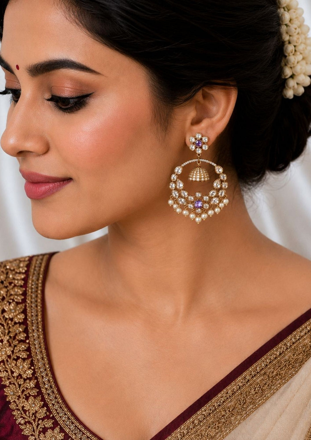 South indian women weaing Zircon diamond gold plated blue Chandbali Long Earrings with hanging guttapusalu design, sparkling white zircon stones, floral pattern detailing, and elegant layered arrangement finished with shiny gold plating. The earrings come with lightweight, sweat proof quality, anti-fade colour, skin-friendly finish, and are suitable for weddings, receptions, festivals, functions, and party wear .