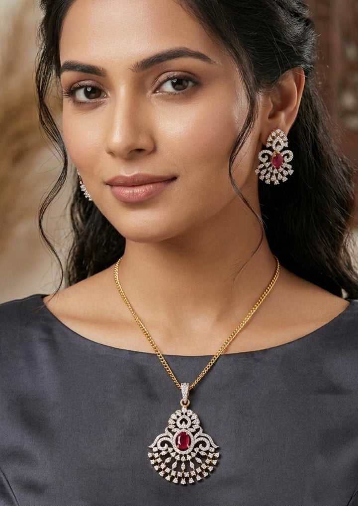 South indian women wearing Zircon diamond gold plated pendant and earring set featuring a large open teardrop style chandelier pendant filled with tiers of shimmering white zircons and an oval-cut central ruby red gemstone. This lightweight matching set comes with smaller identical teardrop ruby earrings, providing an exceptionally brilliant diamond-look appearance suitable for weddings, receptions, festivals, cocktail parties, sarees, gowns, and ethnic fusion wear with skin-friendly quality, anti-fade prem